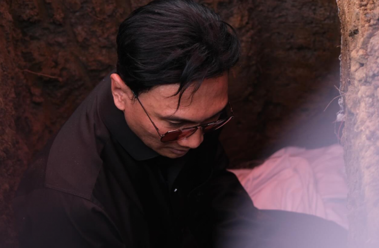 Anji ikut turun ke liang lahat saat prosesi pemakaman ayahnya, Hartiyo. [Instagram @duniamanji]