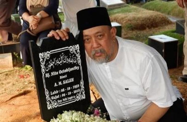 Indro Warko peluk nisan istrinya. [Instagram @indrowarkop_asli]