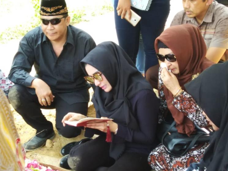 Roro Fitria membacakan Yasin di atas makam ibunya, di TPU Pemda Sleman, Yogyakarta, Selasa (16/10/2018). (Matamata.com/Bima Sandria)