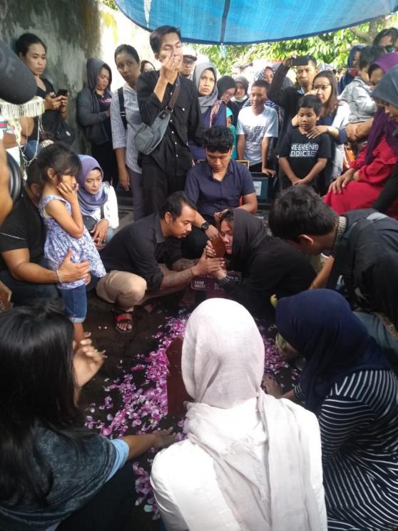 Dewi Sartika memeluk nisan Andi Seventeen. (Matamata.com/Uni Irmagani)