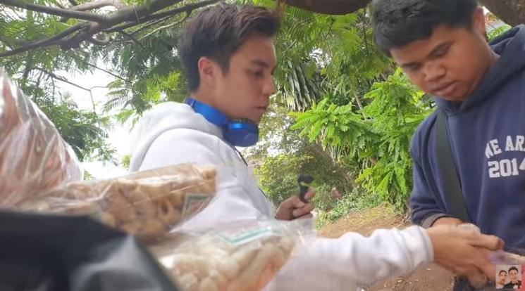 Baim Wong membagikan uang pada penjual kerupuk. (YouTube)