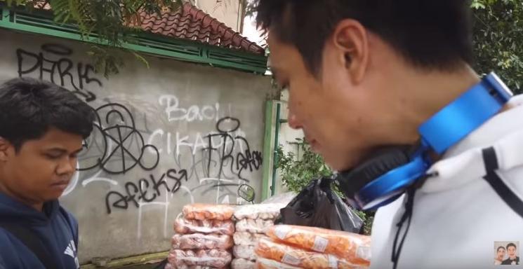 Baim Wong membagikan uang pada penjual kerupuk. (YouTube)