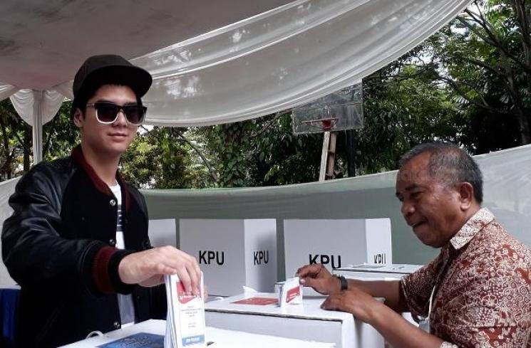 Al Ghazali mengenakan kaus bergambar ayahnya saat mencoblos di TPS dekat rumahnya.