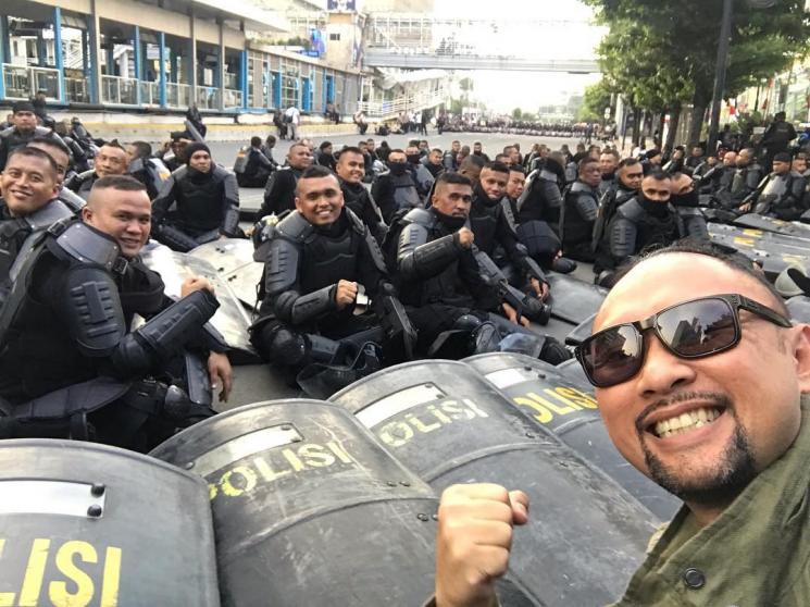 Ronal Surapradja berpose bareng aparat yang menjada demo di Bawaslu. [Instagram]