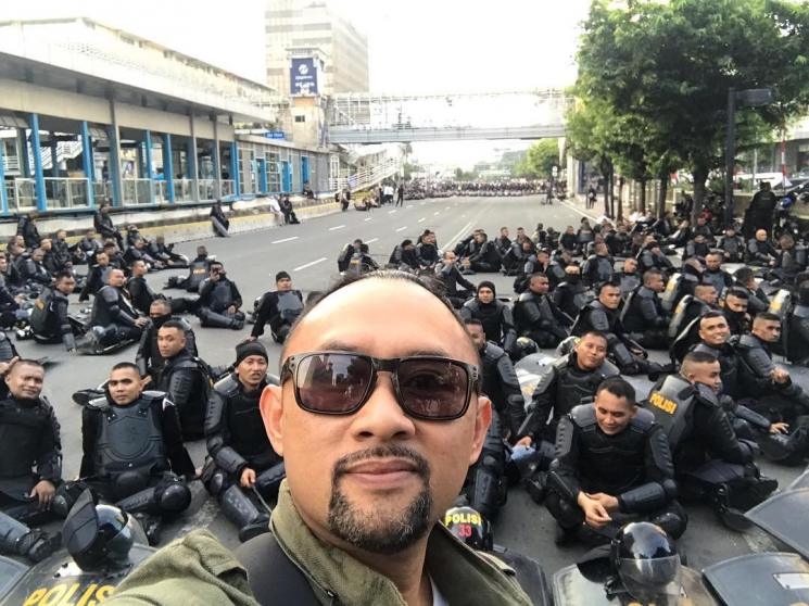 Ronal Surapradja berpose bareng aparat yang menjada demo di Bawaslu. [Instagram]