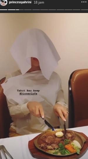 Syahrini tutupi wajah demi hindari asap. [Instagram]
