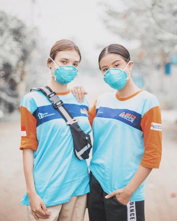 Awkarin (kiri) berpose relawan lain mengenakan masker. [Instagram]