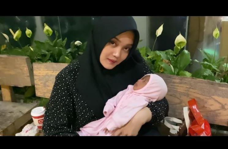 Putri Delina gendong adik sambung. (Youtube/PutriDelina)