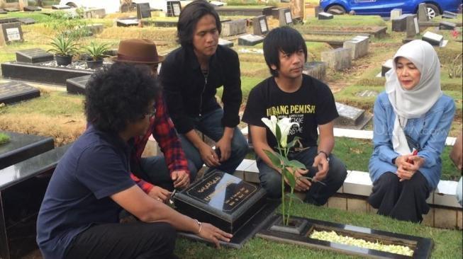 Bersama Damayanti Noor, D'Masiv nyekar ke makam Chrisye. (Sumarni/Matamata.com)