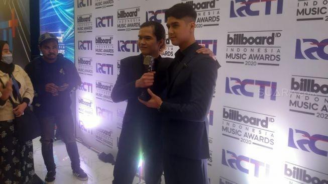 Al Ghazali dan Dul Jaelani menerima penghargaan untuk Dewa 19 di ajang Billboard Indonesia Music Awards 2020, Rabu (26/2/20202). [Ismail/Matamata.com]