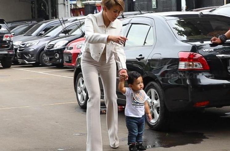 Nikita Mirzani menuntun anak dari pernikahan dengan Dipo latief di PN Jaksel. [Alfian Winanto]