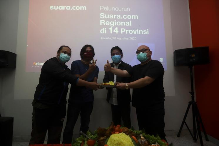 CEO PT Arkadia Digital Media Tbk Wiliam Martaputra (kanan) dan COO PT Arkadia Digital Media Tbk sekaligus Pemimpin Redaksi Suara.com Suwarjono, menyerahkan potongan tumpeng kepada dua koordinator dan penanggung jawab daerah saat acara Peluncuran Suara.com Regional di 14 Provinsi di kantor redaksi di Jakarta, Jumat (28/8/2020). [Suara.com/Angga Budhiyanto]