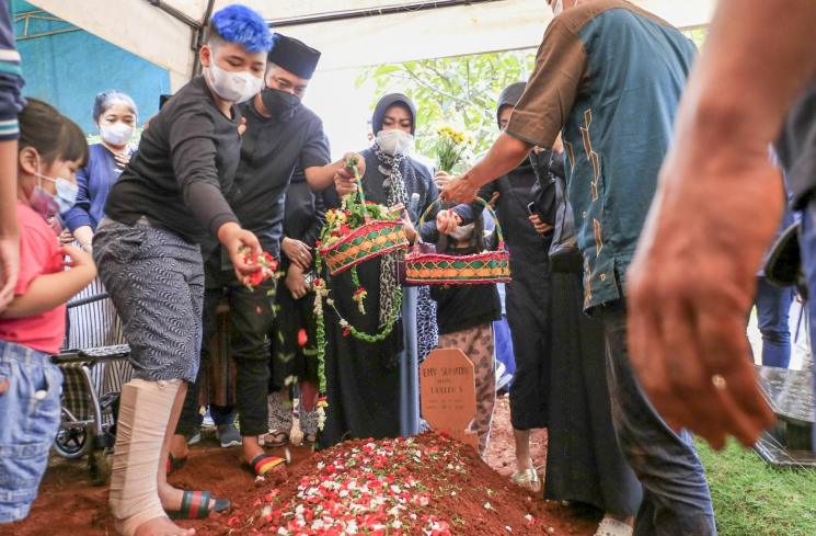 Komedian Denny Cagur berdoa di atas pusara ibunya setelah dimakamkan di TPU Tipar, Depok, Jawa Barat, Selasa (19/1/2021). [Matamata.com/Alfian Winanto]