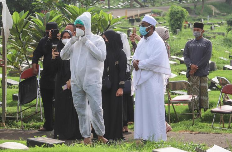 Suami mendiang Presenter Rina Gunawan, Teddy Syah berdoa diatas pusara sang istri saat prosesi pemakaman di TPU Tanah Kusir, Jakarta Selatan, Rabu (3/3/2021). [MataMata.com/Alfian Winanto]