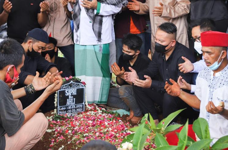 Keluarga dan kerabat berdoa di pusara komedian Sapri Pantun di TPU Ulujami, Pesanggrahan, Jakarta Selatan, Selasa (11/5/2021). [MataMata.com/Alfian Winanto]