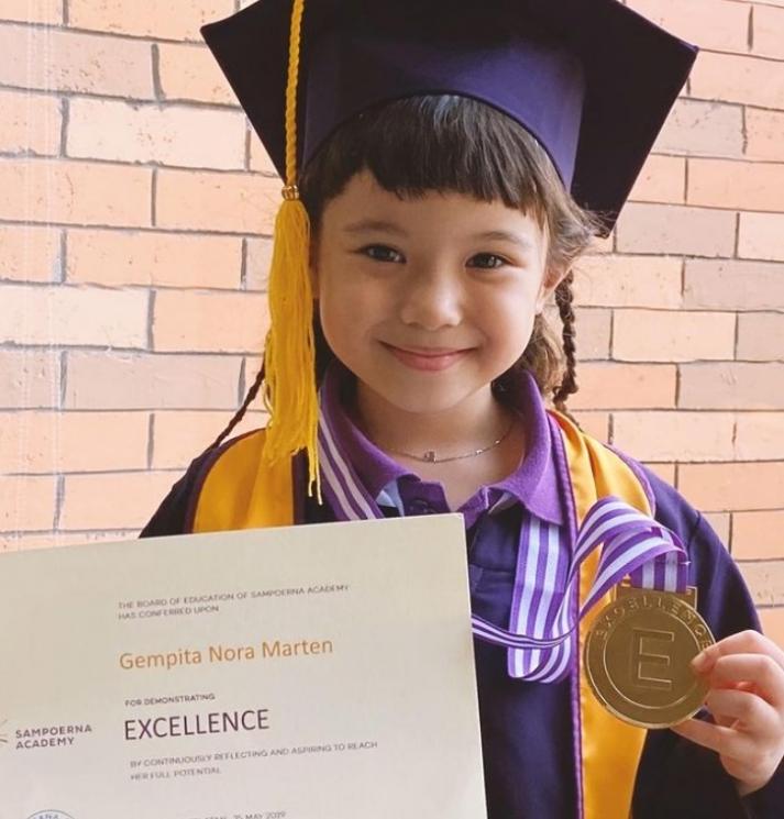Gempi semringah menunjukkan medali kelulusannya. [capture Instagram]