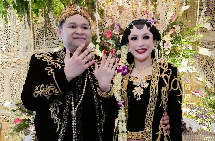Pedangdut Nabilla Gomes dan suami, Muhammad Reza duduk di pelaminan saat melangsungkan resepsi pernikahan di Aula Masjid Kubah Emas, Depok, Jawa Barat, Jumat (28/5/2021). [MataMata.com/Alfian Winanto]