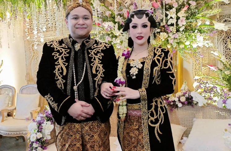 Pedangdut Nabilla Gomes dan suami, Muhammad Reza duduk di pelaminan saat melangsungkan resepsi pernikahan di Aula Masjid Kubah Emas, Depok, Jawa Barat, Jumat (28/5/2021). [MataMata.com/Alfian Winanto]