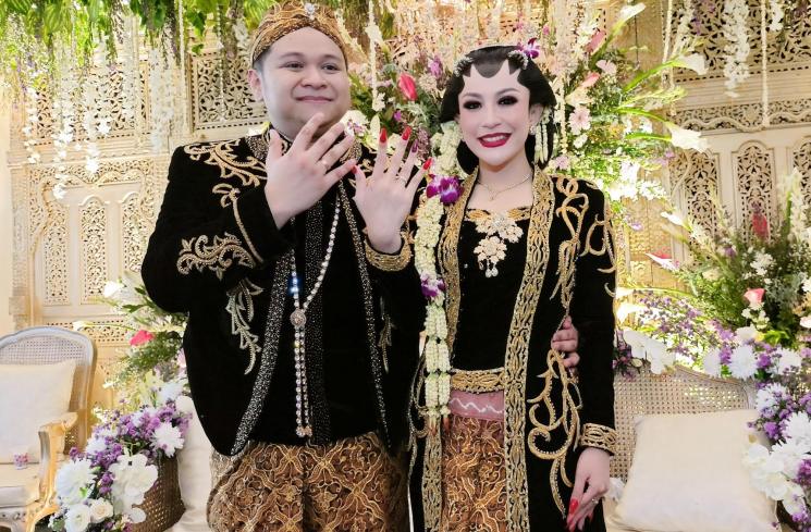 Pedangdut Nabilla Gomes dan suami, Muhammad Reza duduk di pelaminan saat melangsungkan resepsi pernikahan di Aula Masjid Kubah Emas, Depok, Jawa Barat, Jumat (28/5/2021). [MataMata.com/Alfian Winanto]