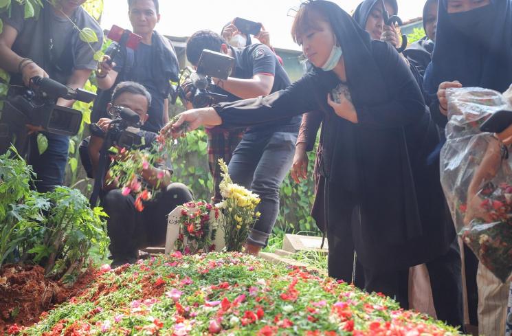 Komedian Mpok Alpa berdoa di atas pusara sang Ayah setelah dimakamkan di Tempat Pemakaman Khusus Keluarga, Jagakarsa, Jakarta Selatan, Kamis (3/6/2021). [MataMata.com/Alfian Winanto]