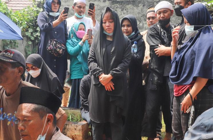 Komedian Mpok Alpa berdoa di atas pusara sang Ayah setelah dimakamkan di Tempat Pemakaman Khusus Keluarga, Jagakarsa, Jakarta Selatan, Kamis (3/6/2021). [MataMata.com/Alfian Winanto]