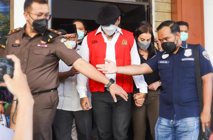 Musisi I Gede Ari Astina atau Jerinx SID mengenakan rompi tahanan berwarna merah usai menjalani pemeriksaan di Kejaksaan Negeri Jakarta Pusat, Rabu (1/12/2021). [Matamata.com/Alfian Winanto]