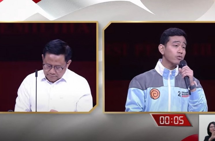 Cawapres nomor urut 1, Muhaimin Iskandar atau Cak Imin mencatat pertanyaan cawapres nomor urut 2, Gibran Rakabuming Raka dalam debat keempat di JCC Senayan, Minggu (21/1/2024). (YouTube/KPU RI)