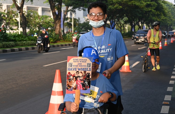Run for Equality 2024_Plan Indonesia_Teman disabilitas membawa poster kesetaraan. (Dok: PLAN Indonesia)