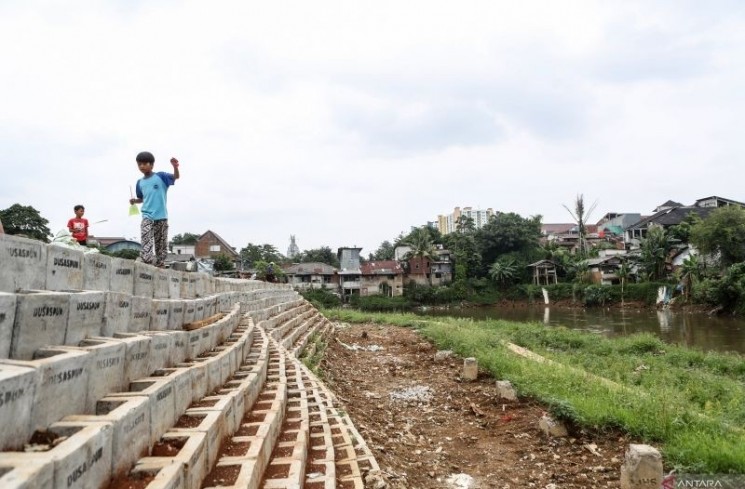 Arsip foto - Seorang anak berjalan di pinggir proyek normalisasi Kali Ciliwung di Rawajati, Jakarta, Kamis (23/1/2025). ANTARA FOTO/Asprilla Dwi AdhaYU
