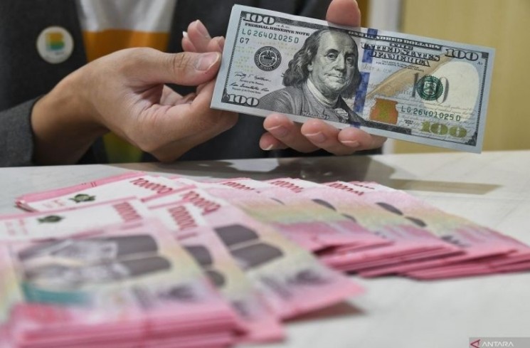 Petugas menyusun uang dolar AS dan rupiah di Bank Syariah Indonesia (BSI), Bekasi, Jawa Barat, Jumat (21/2/2025). ANTARA FOTO/ Fakhri Hermansyah/foc.
