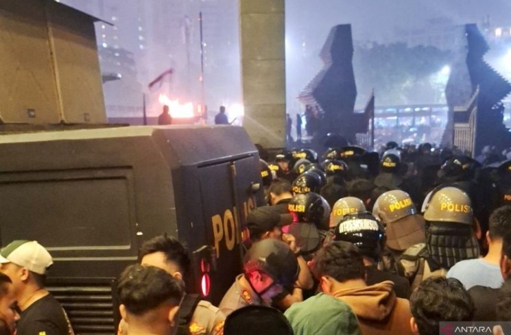 Sejumlah mahasiswa dan masyarakat masih tetap menyampaikan orasi saat hujan di Polda Metro Jaya, Jakarta, Jumat (29/8/2025). ANTARA/Luthfia Miranda Putri.
