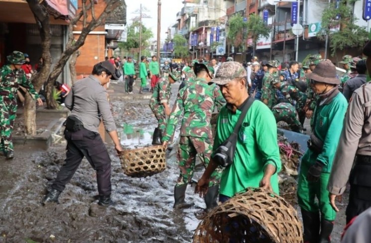 Ratusan prajurit TNI-Polri dan ASN Pemerintah Kota Denpasar membersikan sisa-sisa kotoran akibat banjir di Kawasan Heritage Jalan Gajah Mada, Pasar Badung dan Pasar Kumbasari, pada Kamis (11/9/2025). (ANTARA/HO-Humas Pemkot Denpasar)
