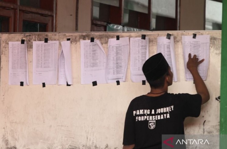Seorang warga mencari nama korban ambruknya bangunan mushalla di Pondok Pesantren (Ponpes) Al Khoziny, Kecamatan Buduran, Sidoarjo, Jawa Timur, Selasa (30/9/2025). ANTARA FOTO/Umarul Faruq
