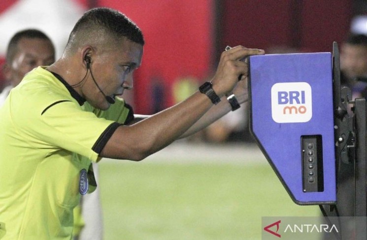 Wasit Agung Setiayawan (kanan) melihat Video Assistant Referee (VAR) setelah pesepak bola Malut United dijatuhkan penjaga gawang Borneo FC Nadeo Winata pada laga lanjutan BRI Liga 1 di Stadion Gelora Kie Raha Ternate, Maluku Utara, Senin (10/2/2025). Tuan rumah Malut United mengalahkan tamunya Borneo FC Samarinda dengan skor 3-0. ANTARA FOTO/Andri Saputra/YU
