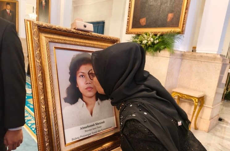 Adik Marsinah, Wijiati (54), mencium foto sang kakak seusai agenda Penganugerahan Pahlawan Nasional kepada Marsinah di Istana Negara, Jakarta, Senin (10/11/2025). ANTARA/Andi Firdaus
