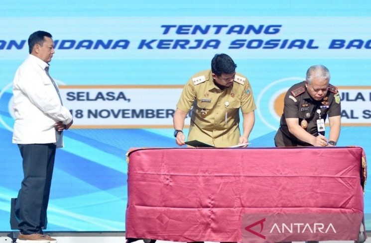 Pelaksana tugas Jaksa Agung Muda Bidang Tindak Pidana Umum Kejagung RI Undang Mugopal (kiri) menyaksikan penandatanganan perjanjian kerja sama oleh Gubernur Sumatera Utara Bobby Afif Nasution (tengah) dengan Kepala Kejaksaan Tinggi Sumut Harli Siregar (kanan) di Aula Raja Inal Siregar, Kantor Gubernur Sumut, Selasa (18/11/2025).  ANTARA/HO-Diskominfo Sumut
