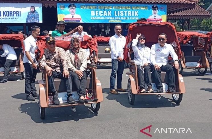 Bupati Banyumas Sadewo Tri Lastiono (kiri) dan Ketua Yayasan Gerakan Solidaritas Nasional (GSN) Letjen TNI (Purn) Teguh Arief Indratmoko (kanan) menumpang becak listrik bantuan Presiden Prabowo Subianto di halaman Pendopo Si Panji, Purwokerto, Kabupaten Banyumas, Jawa Tengah, Selasa (2/12/2025). ANTARA/Sumarwoto
