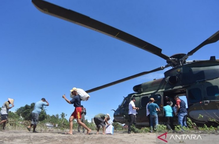 Warga memindahkan bantuan yang didistribusikan dari Helikopter Caracal Skadron Udara 8 Lanud Atang Sendjaja di daerah terisolir akibat bencana di Nagari Tiku V Jorong, Agam, Sumatera Barat, Senin (1/12/2025). TNI-AU melalui Lanud Sutan Sjahrir Padang mendistribusikan 4.500 kilogram logistik untuk korban banjir bandang di Maligi, Pasaman Barat, Sungai Pua Palembayan dan Tiku V Jorong di Agam. ANTARA FOTO/Iggoy el Fitra/YU
