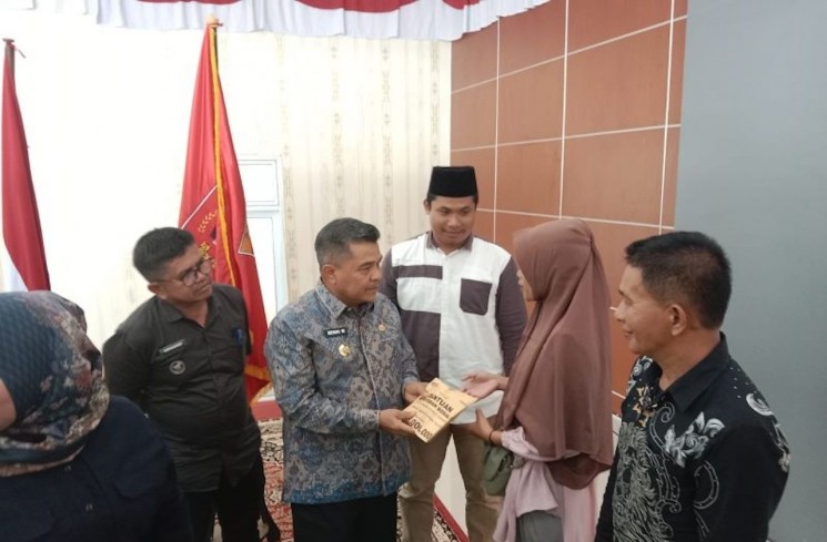 Bupati Agam Benni Warlis sedang menyalurkan santunan ahli waris tahap dua di Balairung Rumah Dinas Bupati Agam, Jumat (3/4/2026). ANTARA/Yusrizal.
